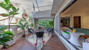 een kamer met een balkon met stoelen en een tafel bij Villa Belle Vue- 4BHK Private Pool & Party Hall By StayMonkey in Lonavala