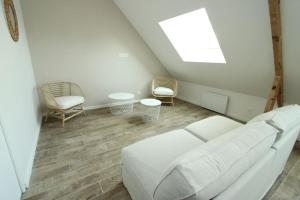 a living room with a white couch and two chairs at Appartement « La brise de Mer » - 50m de la plage in Bray-Dunes