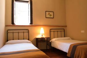two beds in a room with a window at Pozuelo 3 JABUGO in Jabugo