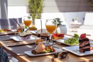 uma mesa de madeira coberta com pratos de comida e bebidas em Lithos Luxury Suites em Tinos Town
