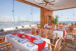 a restaurant with tables and chairs with a view of the ocean at Sunrise Arabian Beach Resort in Sharm El Sheikh