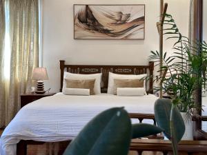 1 dormitorio con 1 cama y una pintura en la pared en Rosewood By The Beach Goa en Benaulim