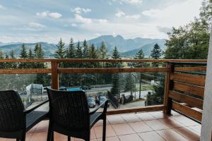 einen Balkon mit Stühlen und Bergblick in der Unterkunft New Apartamenty Jan in Zakopane