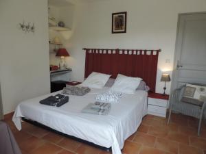 1 dormitorio con 1 cama blanca grande y toallas. en Le Faré Tchanqué Chambre d’hôtes Référence, en Cavaillon