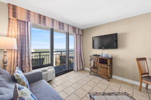 a living room with a couch and a flat screen tv at Seaside Serenity Oceanview Suite w Amazing Views 604 in Myrtle Beach