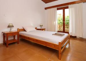 a bedroom with a bed and two tables and a window at Belle Epoque - Holiday Home in Aegina Town