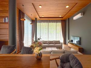 a living room with a couch and a table at Villa Menara Bang Tao in Phuket Town