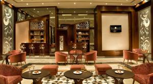 a hotel lobby with tables and chairs and a bar at Sunrise Arabian Beach Resort in Sharm El Sheikh