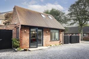 a brick house with glass doors on a driveway at Blackwood in Hornsea