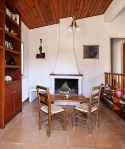 a dining room with a table and chairs and a fireplace at Belle Epoque - Holiday Home in Aegina Town