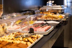 a buffet line with different types of food on display at The Londoner Hotel St. Julian's in St. Julianʼs