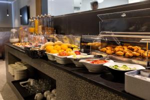 a buffet line with many different types of food at The Londoner Hotel St. Julian's in St. Julianʼs