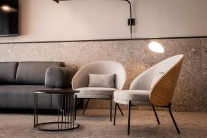 two chairs and a couch in a room at The Londoner Hotel St. Julian's in St. Julianʼs