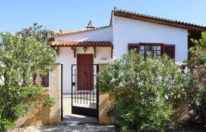 a white house with a black gate and trees at Belle Epoque - Holiday Home in Aegina Town