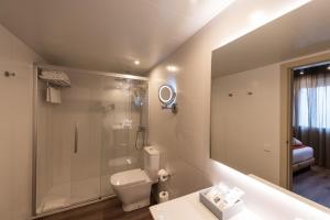 a bathroom with a shower and a toilet and a sink at Atenea Rekord Suites Barcelona in Barcelona +37 photos