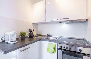 une cuisine blanche avec un évier et une cuisinière dans l'établissement SummerBreak 1 Scharbeutz, à Scharbeutz