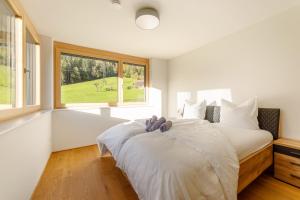 een slaapkamer met een groot wit bed en een raam bij Ferienwohnung "Urlaub am Arlberg" in Wald am Arlberg