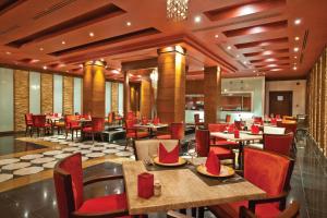 a restaurant with tables and chairs with red napkins on them at Sunrise Arabian Beach Resort in Sharm El Sheikh