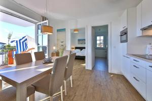 a kitchen and dining room with a table and chairs at Dünenrose Fewo Wolkenlos in Börgerende-Rethwisch +14 photos