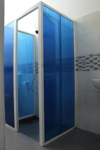a bathroom with blue glass doors and a sink at Perla Fisherman Bay in Weligama