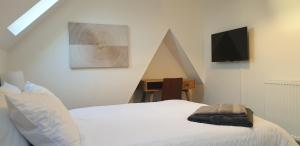 a bedroom with a bed and a tv on the wall at Comfort Stay Rooms in Portslade