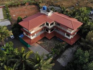 une vue aérienne sur une maison avec un toit rouge dans l'établissement Vasantam Beach Resort, à Kashid