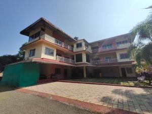 un grand immeuble d'appartements avec une grande cour dans l'établissement Vasantam Beach Resort, à Kashid