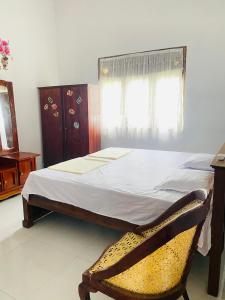 a bedroom with a bed and a chair and a window at SAKURA Guest House Tourist only in Wariyapola