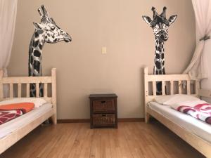 two giraffes standing in a room with two beds at ParadiseGarden Backpackers in Windhoek