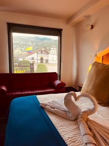 a bedroom with a bed with a heart shaped towel on it at Camino A La Villa Cucaita Hotel in Cucaita