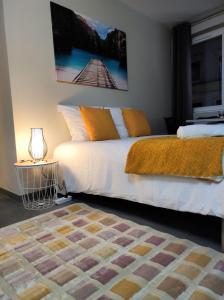 een slaapkamer met een wit bed en een oranje deken bij Le LUX 31 in Thionville
