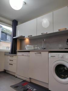 een keuken met een wasmachine en een wastafel bij Le LUX 31 in Thionville