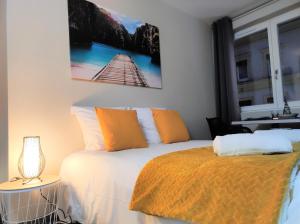 een slaapkamer met een bed met een oranje deken bij Le LUX 31 in Thionville