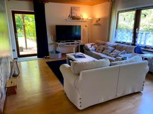 uma sala de estar com sofás e uma televisão de ecrã plano em Opa´s Häuschen em Westerholz