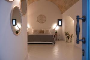 sypialnia z łóżkiem i lustrem w obiekcie Vecchia Mottola Albergo Diffuso w mieście Mottola