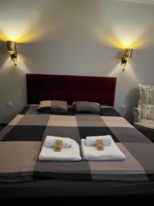 a bedroom with a large bed with two white towels at Cosy Apartments Deluxe in Krakow