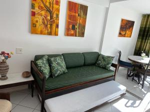 een woonkamer met een groene bank en een tafel bij Apartamento Porto Praia do Forte in Praia do Forte