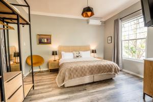 a bedroom with a bed and a window at Corner House Residence in Franschhoek