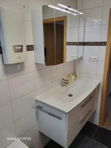 a white bathroom with a sink and a mirror at Apartment Bochum in Bochum