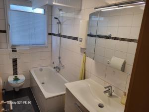 a bathroom with a sink and a tub and a toilet at Apartment Bochum in Bochum
