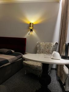 a room with a bed and a table and a chair at Cosy Apartments Deluxe in Krakow
