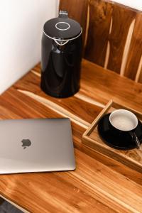 a laptop on a wooden table with a coffee maker at Happiness Apartments Bali Ubud in Ubud