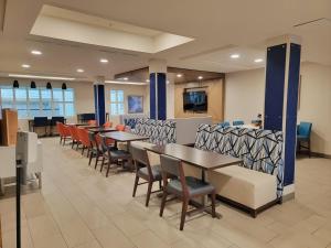 a dining room with tables and chairs in a cafeteria at Holiday Inn Express Hotel & Suites Idaho Falls, an IHG Hotel in Idaho Falls