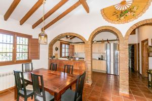 Cortijo Bellavista في كومبيتا: مطبخ وغرفة طعام مع طاولة وكراسي خشبية
