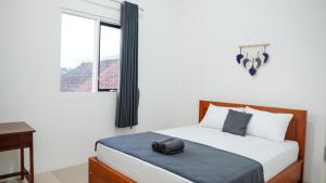 a bedroom with a bed with a camera on it at Wangi Homestay in Banyuwangi