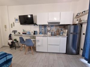 a kitchen with white cabinets and a stainless steel refrigerator at Alloggio in residence con pontile privato e accesso diretto al mare in Santa Marinella +17 photos