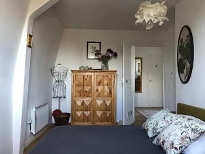 a bedroom with a bed and a wooden dresser at une maison à la campagne in Beaune-la-Rolande