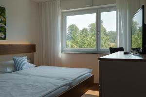 ヴァッサーブルクにあるFerienhaus Seezeichenのベッドルーム1室(ベッド1台、デスク、窓付)