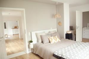 a white bedroom with a bed and a mirror at Im Fachwerk – Wohlfühlen, Entspannen & Wandern im Grünen in Gladenbach