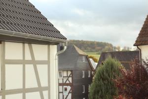 Aussicht von der Seite eines Hauses mit Dächern in der Unterkunft Im Fachwerk – Wohlfühlen, Entspannen & Wandern im Grünen in Gladenbach